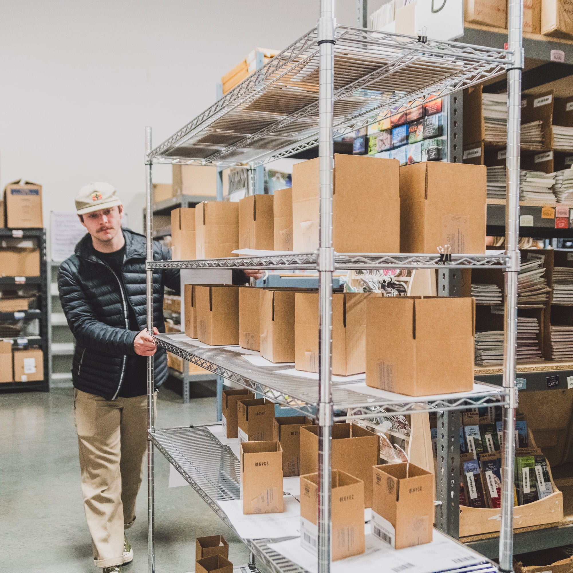 Collective Pallet team member preparing boxed inventory for Fulfillment by Amazon (FBA) shipment inside an organized ecommerce warehouse workspace.